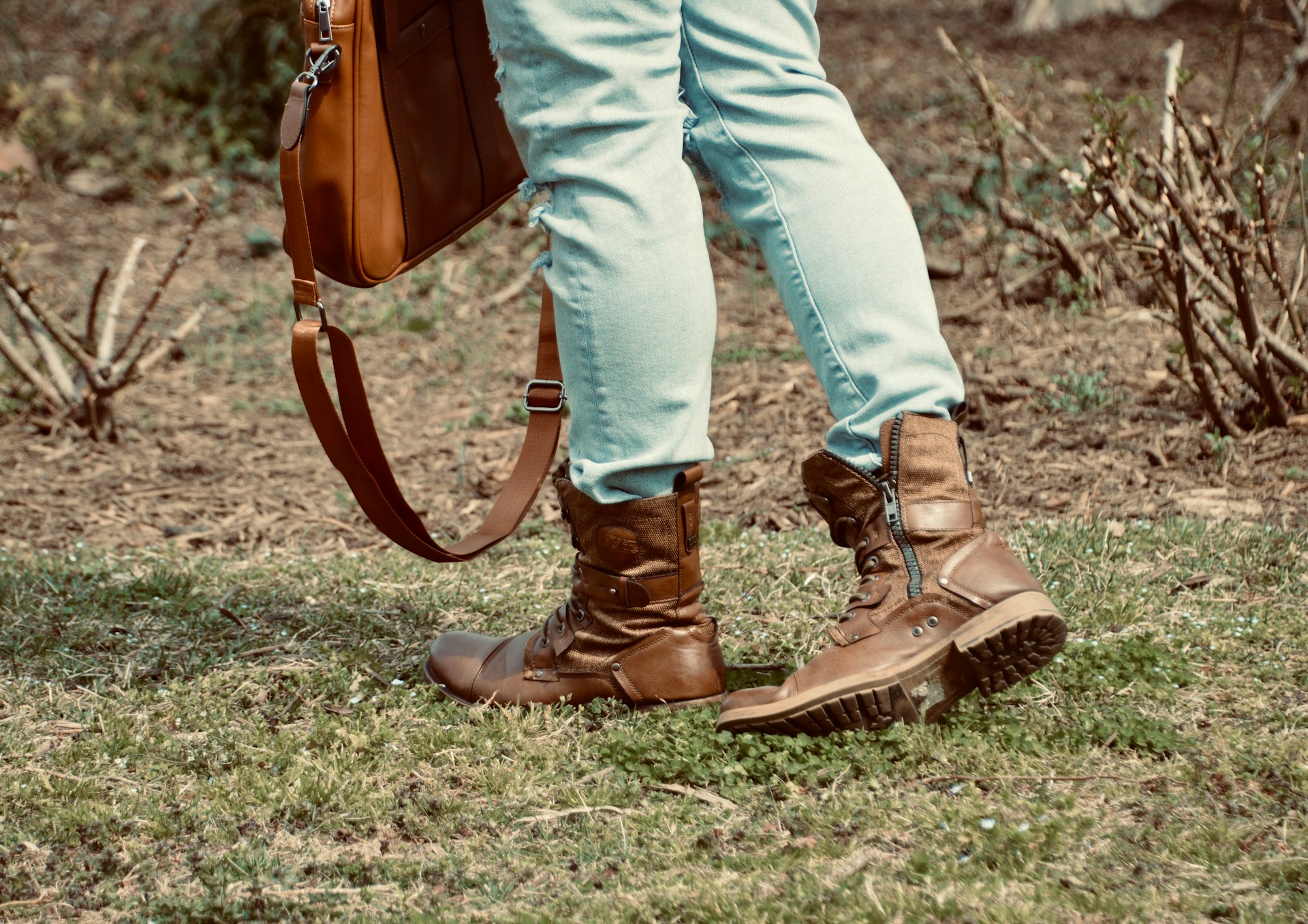 a woman in brown leather boots and blue jeans